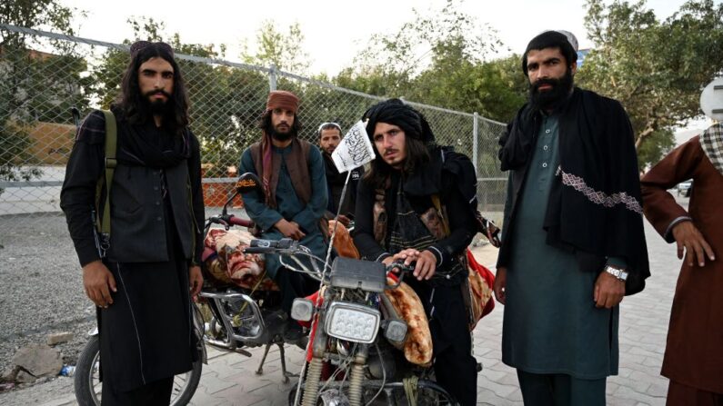 Unos terroristas talibanes de pie a lo largo de una carretera en Kabul el 18 de agosto de 2021, tras la toma militar de Afganistán por parte de los talibanes. (Foto de WAKIL KOHSAR/AFP vía Getty Images)