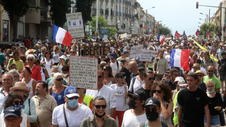 Manifestantes marchan durante una jornada nacional de protesta contra la vacunación obligatoria contra covid-19 para determinados trabajadores y el uso obligatorio de la tarjeta sanitaria en Perpiñán, sur de Francia, el 21 de agosto de 2021. (Raymond Roig/AFP vía Getty Images)