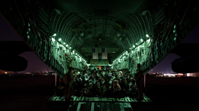 En esta imagen proporcionada por la Fuerza Aérea de los Estados Unidos, una tripulación aérea asignada al 816º Escuadrón Expedicionario de Transporte Aéreo ayuda a los evacuados de Afganistán a bordo de un avión C-17 Globemaster III en en el Aeropuerto Internacional Hamid Karzai, en Kabul, el 21 de agosto de 2021.  (Foto de Taylor Crul/Fuerza Aérea de EE.UU. vía Getty Images)
