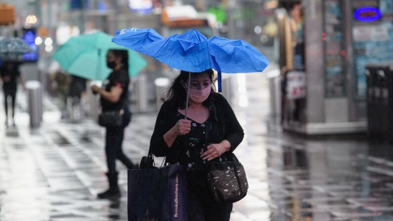 Una persona con un paraguas camina por Time Square mientras llueve en Nueva York (EE.UU.) el 23 de agosto de 2021. (Angela Weiss/AFP vía Getty Images)