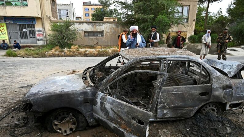 Talibanes observan coche dañado tras el lanzamiento de cohetes en Kabul el 30 de agosto de 2021. (Wakil Kohsar / AFP vía Getty Images)