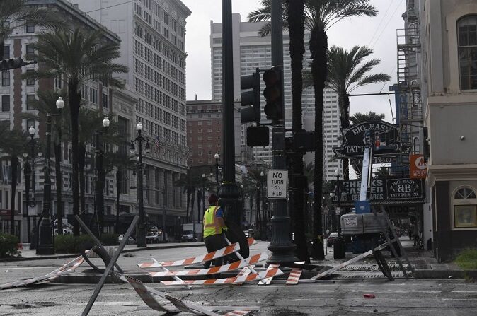 Un trabajador retira las barreras que fueron arrastradas por el viento en la calle Canal de Nueva Orleans, Luisiana, el 30 de agosto de 2021, después de que el huracán Ida tocara tierra.(PATRICK T. FALLON/AFP vía Getty Images)