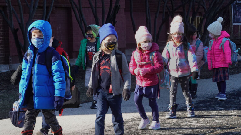 Los estudiantes son escoltados desde Hawthorne Scholastic Academy para reunirse con sus padres después de su primer día de aprendizaje en persona el 01 de marzo de 2021 en Chicago, Illinois. (Scott Olson/Getty Images)