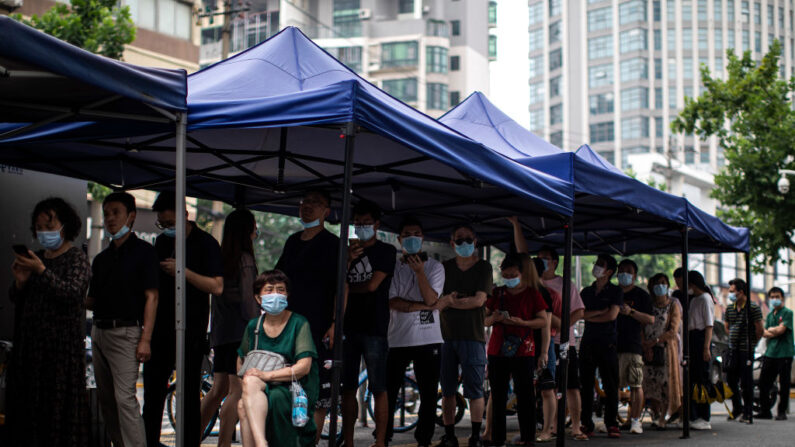 Los residentes llevan una mascarilla mientras hacen fila para recibir las vacunas COVID-19 en un centro de vacunación el 21 de junio de 2021 en Wuhan, China.(Getty Images)