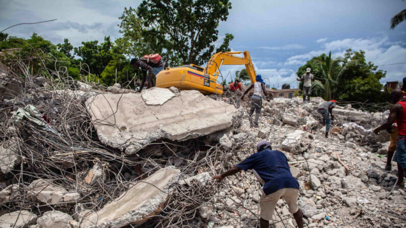 Haitianos buscan metales valiosos entre los escombros de un edificio derrumbado tras el terremoto de 7.2 grados que sacudió Haití el 16 de agosto de 2021 en Les Cayes, Haití. (Richard Pierrin/Getty Images)