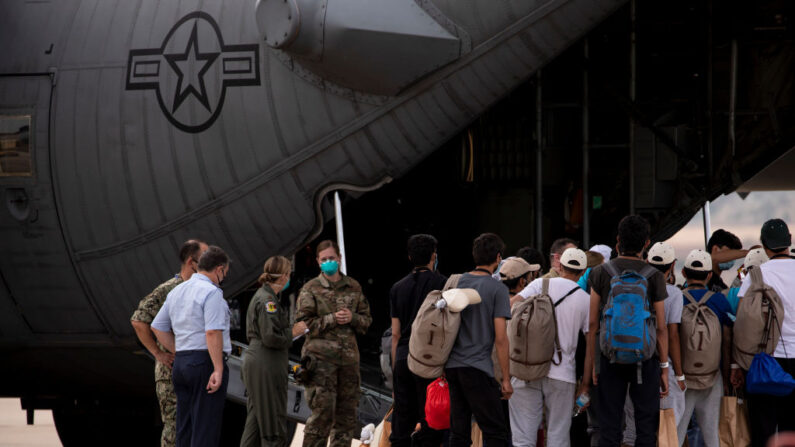 Los afganos evacuados de Kabul hacen fila para embarcar en un avión de las fuerzas aéreas estadounidenses en la Base Aérea Militar de Torrejón el 24 de agosto de 2021 en Madrid, España. (Foto de Pablo Blazquez Dominguez/Getty Images)