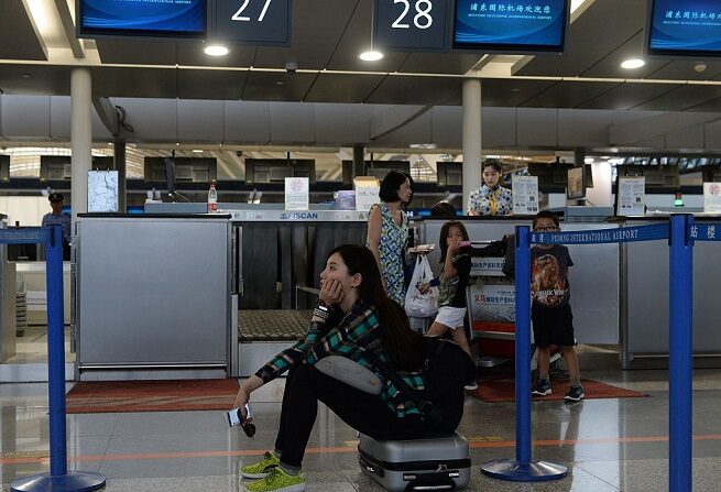 Pasajeros esperan en el interior del aeropuerto de Pudong, en Shanghai, 12 de junio de 2016. (STR/AFP vía Getty Images)
