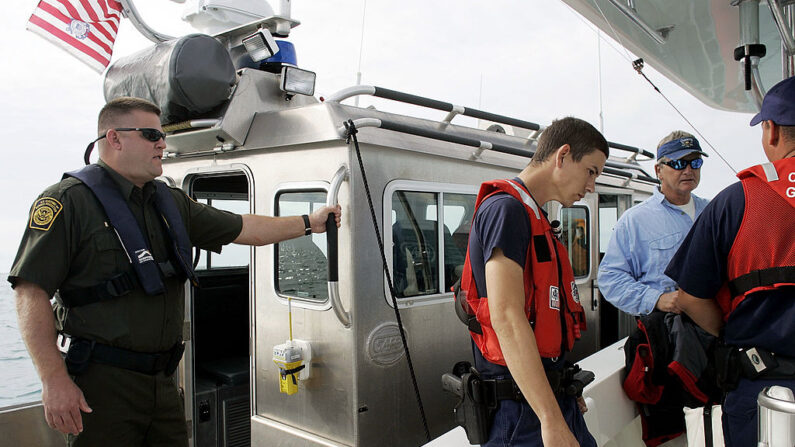 El agente de la Patrulla Fronteriza de EE.UU. Dan Schaefer (i) ayuda a la Guardia Costera mientras interceptan un barco y hablan con su capitán el 30 de enero de 2007 en Marathon, Florida (EE.UU.). (Joe Raedle/Getty Images)