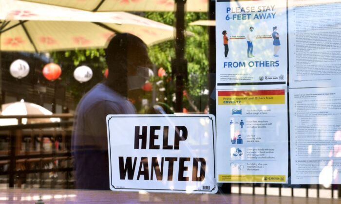 Un cartel de "Se busca personal" está colocado junto a las directrices de seguridad COVID-19 frente a un restaurante en Los Ángeles, California, el 28 de mayo de 2021. (Frederic J. Brown/AFP vía Getty Images)