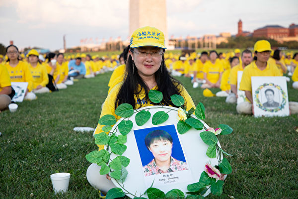 Yang Chunhua sostiene una ofrenda floral en conmemoración de su hermana, Yang Chunling, quien falleció en 2014 como resultado de la persecución de Beijing contra Falun Gong, durante un evento en Washington el 18 de julio de 2019. (The Epoch Times)