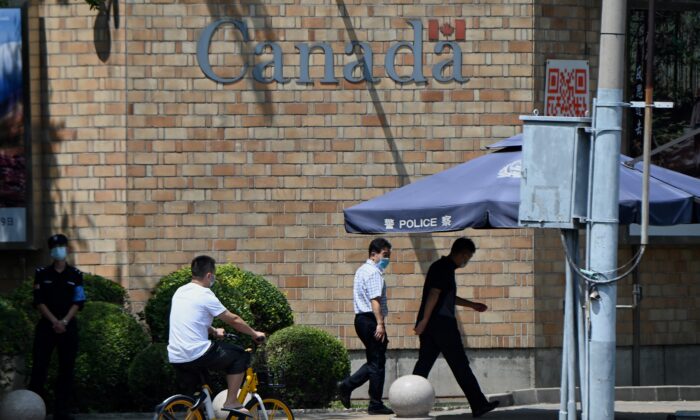 La gente pasa frente a la embajada de Canadá después que un tribunal chino confirmó la sentencia de muerte contra el ciudadano canadiense, Robert Lloyd Schellenberg, por contrabando de drogas, en Beijing, el 10 de agosto de 2021. (Noel Celis/AFP a través de Getty Images)