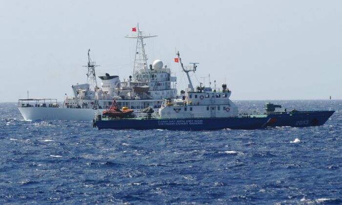 Un barco guardacostas chino (atrás) navega junto a un barco guardacostas vietnamita (delante) cerca de una plataforma de perforación petrolífera de China en aguas disputadas del mar de China Meridional, el 14 de mayo de 2014. (Hoang Dinh Nam/AFP vía Getty Images)