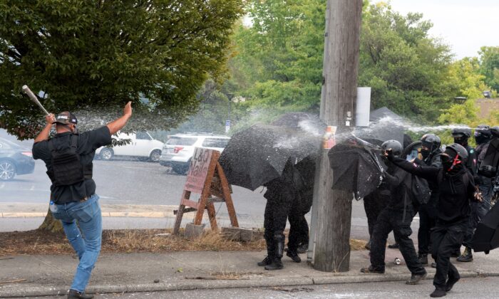 Los miembros de Antifa (der.) atacan a un miembro de Proud Boys en Portland, Oregón, el 22 de agosto de 2021. (Mathieu Lewis-Rolland/AFP a través de Getty Images)