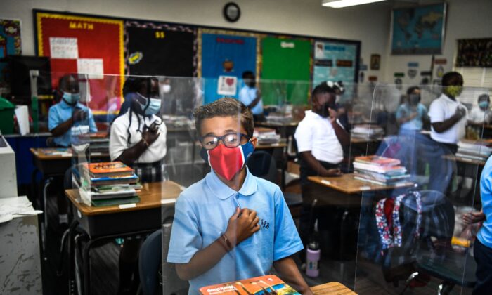Unos estudiantes asisten a su primer día de clases después de las vacaciones de verano en la Escuela Católica de San Lorenzo, al norte de Miami, el 18 de agosto de 2021. (Chandan Khanna/AFP vía Getty Images)