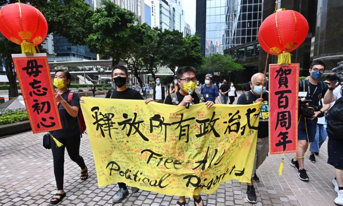 Cuatro miembros de la Liga de Socialdemócratas de Hong Kong se manifiestan en las calles para instar al régimen de Beijing a que libere a todos los presos políticos, en Hong Kong, el 1 de julio de 2021. (Song Bilong/The Epoch Times)