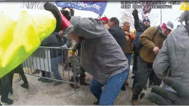 En esta imagen del video, un hombre identificado por las autoridades como Julian Khater, en el centro a la derecha, rocía una sustancia química hacia los policías en Washington el 6 de enero de 2021 (FBI).