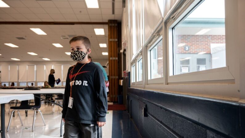 Un estudiante con mascarilla camina en fila por la cafetería de la escuela primaria Medora en Louisville, Ky., El 17 de marzo de 2021 (Jon Cherry/Getty Images).