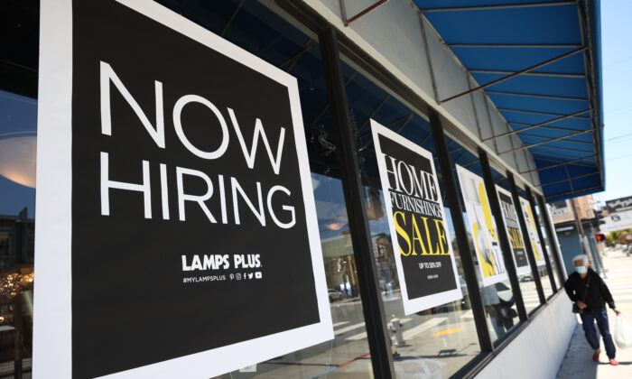 Un peatón camina junto a un cartel de "Now Hiring" fuera de una tienda Lamps Plus en San Francisco, California, el 3 de junio de 2021. (Justin Sullivan/Getty Images)
