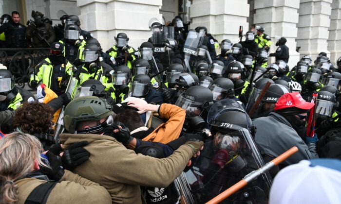 Un grupo de manifestantes se enfrenta a varios agentes de policía en frente del edificio del Capitolio de EE. UU. en Washington el 6 de enero de 2021. (Roberto Schmidt/AFP a través de Getty Images)
