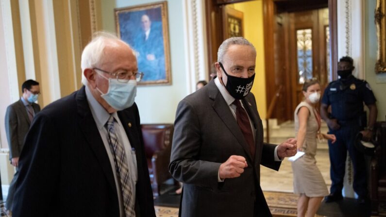 El senador Bernie Sanders (L) (I-Vt.) camina con el líder de la mayoría del Senado, Chuck Schumer (D-N.Y.), después de la reunión sobre el presupuesto de 3.5 billones de dólares en Washington el 9 de agosto de 2021. (Win McNamee/Getty Images)