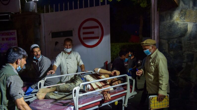 El personal médico y del hospital lleva a un hombre herido en una camilla para recibir tratamiento después de las explosiones en Kabul, Afganistán, el 26 de agosto de 2021. (Wakil Kohsar/AFP vía Getty Images)