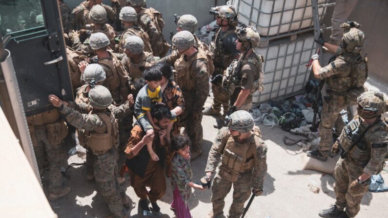 Marines estadounidenses y fuerzas de la coalición noruega ayudan a la seguridad en un puesto de control de evacuación para garantizar que los evacuados sean procesados de forma segura en el aeropuerto internacional Hamid Karzai, en Kabul, Afganistán, el 20 de agosto de 2021. (Cuerpo de Marines de Estados Unidos/Sargento Primero Victor Mancilla)