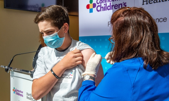 Max Zito, de 13 años, es vacunado en el centro de vacunación masiva de Hartford Healthcares en el Centro de Convenciones de Connecticut en Hartford, Connecticut, el 13 de mayo de 2021. (Joseph Prezioso/AFP vía Getty Images)