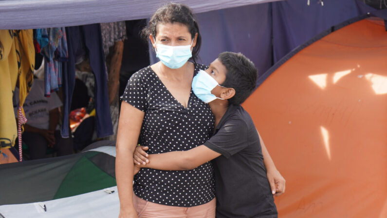 Un niño abraza a su madre en un campo de refugiados en Reynosa, México, el 28 de agosto de 2021. (Jackson Elliott/The Epoch Times)