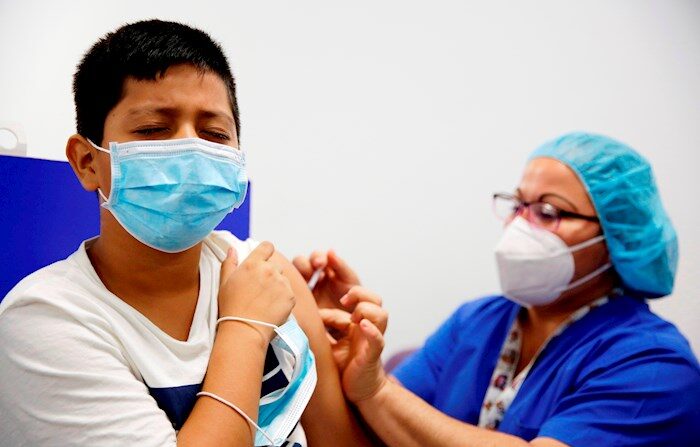 Un niño recibe su primera dosis de la vacuna contra la COVID-19, hoy, en el centro de vacunación del Hospital El Salvador, en San Salvador. EFE/Rodrigo Sura