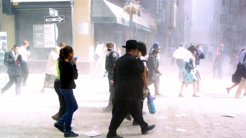 Los peatones se abren paso entre el polvo del bajo Manhattan en Nueva York el 11 de septiembre de 2001, después de que dos aviones secuestrados se estrellaran contra el World Trade Center. (Doug Kanter/AFP vía Getty Images)