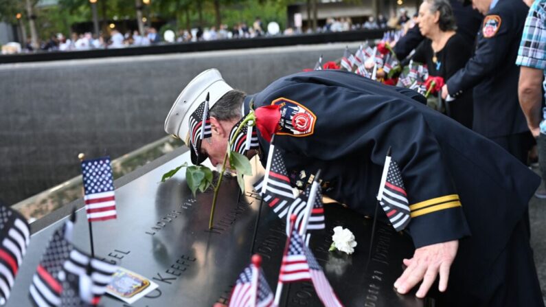 El jefe de paramédicos retirado Charlie Wells besa el nombre de un familiar muerto en el ataque al World Trade Center en el Museo y Memorial Nacional del 9/11 durante una ceremonia que conmemora el 20º aniversario de los ataques del 9/11 en Nueva York, el 11 de septiembre de 2021. (David Handschuh/AFP/Getty Images)