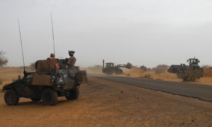 Dos soldados de la misión antiterrorista Barkhane en la región africana del Sahel patrullan a bordo de un vehículo blindado ligero (LAV) para observar la construcción de la nueva base francesa en Gossi, centro de Malí, el 25 de marzo de 2019. (Daphne Benoit/AFP vía Getty Images)