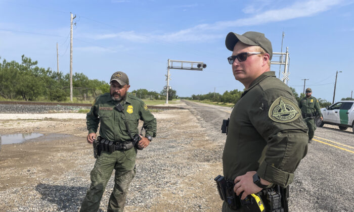 Un policía estatal de Nebraska (centro) ayuda a la Patrulla Fronteriza a detener a los inmigrantes ilegales mientras está desplegado en Texas, en el Condado de Kinney (Texas), el 21 de julio de 2021. (Charlotte Cuthbertson/The Epoch Times)