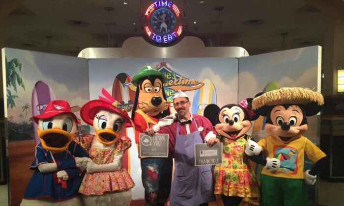 Nick Caturano, empleado desde hace 16 años de Disney World en Orlando, Fa, posa con varios personajes de Disney en un evento reciente. (Allan Stein/The Epoch Times)
