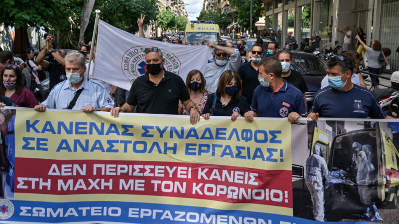 Trabajadores sanitarios y personal de ambulancias protestan con pancartas contra las vacunas contra covid-19 obligatorias para los trabajadores sanitarios en el centro de Atenas (Grecia) el 2 de septiembre de 2021. (Louisa Gouliamaki/AFP vía Getty Images)
