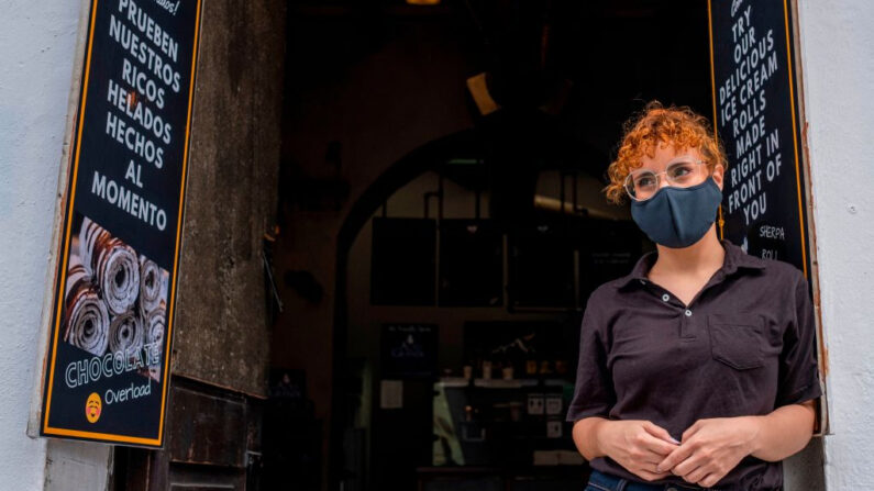 Una camarera de restaurante con una mascarilla protectora espera a los clientes en el Viejo San Juan, Puerto Rico, el 30 de junio de 2020. (Ricardo Arduengo/AFP vía Getty Images)