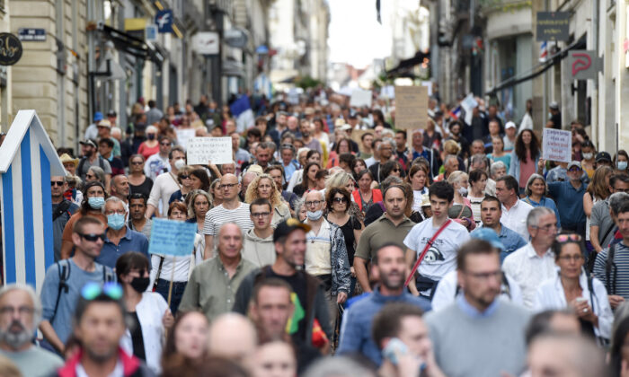 Manifestantes sostienen pancartas y corean consignas mientras marchan durante una concentración en Nantes, oeste de Francia, el 18 de septiembre de 2021. (Sebastien Salom-gomis/AFP vía Getty Images)