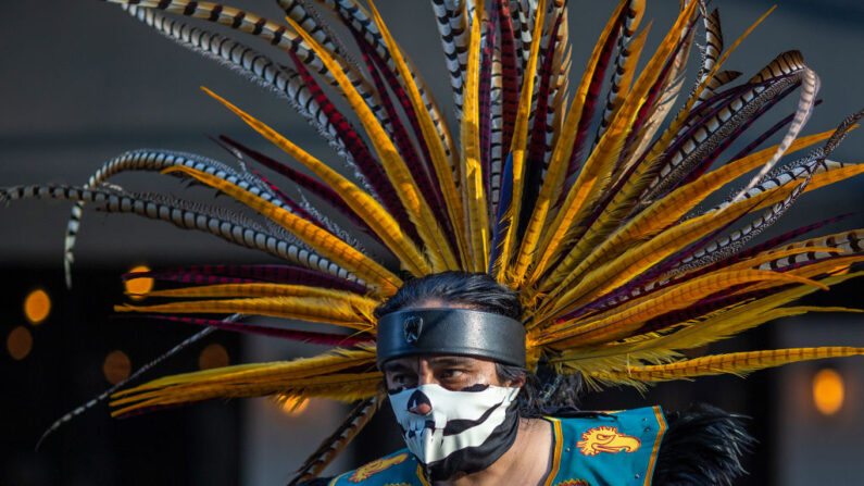 Un bailarín azteca participa en una marcha, en Los Ángeles, el 1 de mayo de 2019. (David McNew/Getty Images)