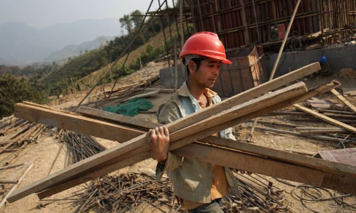 Un trabajador chino transporta materiales para un proyecto de la Iniciativa de la Franja y la Ruta de China, de un billón de dólares, en Laos, el 8 de febrero de 2020 (Aidan Jones/AFP vía Getty Images)