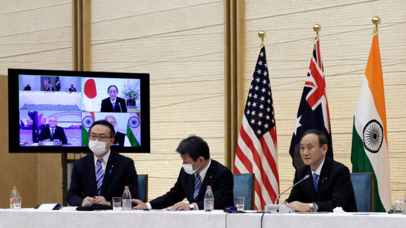 El primer ministro de Japón, Yoshihide Suga (Der.), y el ministro de Asuntos Exteriores de Japón, Toshimitsu Motegi (Centro), junto a un monitor que muestra la reunión virtual con el presidente de Estados Unidos, Joe Biden (arriba a la izquierda), el primer ministro de Australia, Scott Morrison (abajo a la izquierda), y el primer ministro de la India, Narendra Modi (abajo a la derecha), durante la reunión virtual del Quadrilateral Security Dialogue (Quad), en su sede oficial de Tokio, el 12 de marzo de 2021. (Foto de KIYOSHI OTA/POOL/AFP a través de Getty Images)