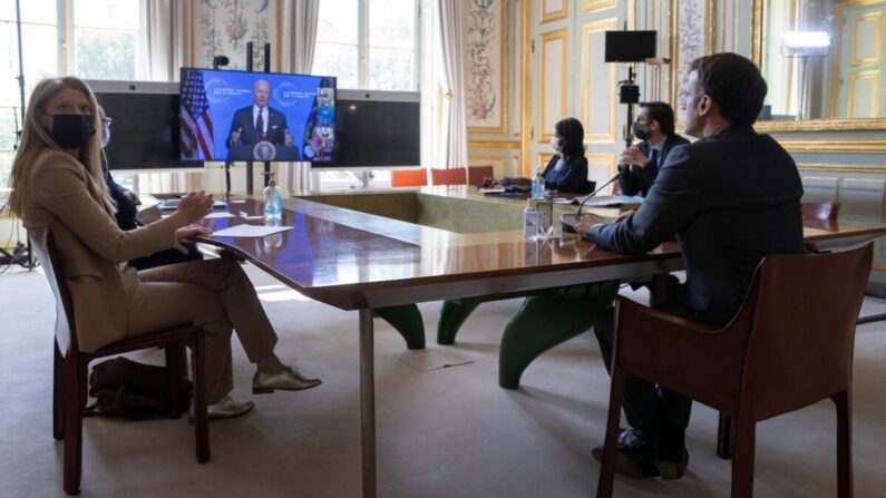 El presidente de Francia, Emmanuel Macron, escucha al presidente de Estados Unidos, Joe Biden (en la pantalla), durante una videoconferencia virtual de la Cumbre del Clima del Día de la Tierra, en el Palacio del Elíseo, en París, el 22 de abril de 2021. (Ian Langsdon/AFP vía Getty Images)