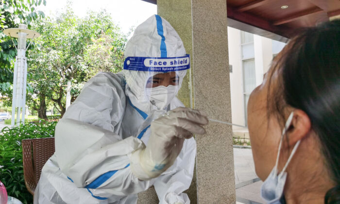 Una mujer se somete a una prueba de ácido nucleico para detectar la presencia del coronavirus causante de COVID-19 en un hotel de la ciudad de Ruili, fronteriza con Birmania, en la provincia suroccidental china de Yunnan, el 8 de julio de 2021. (STR/AFP vía Getty Images)