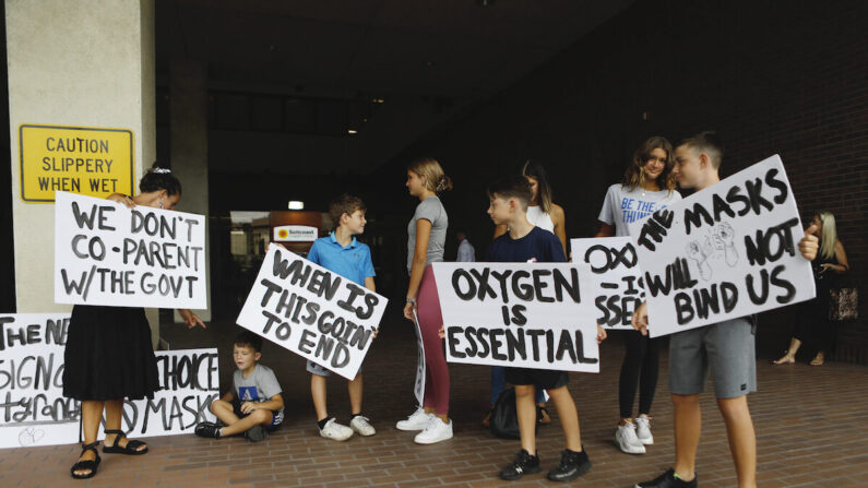 Las familias protestan contra cualquier posible obligación de usar mascarillas antes de la reunión de la Junta Escolar del Condado de Hillsborough celebrada en la oficina del distrito en Tampa, Florida, el 27 de julio de 2021. (Octavio Jones/Getty Images)