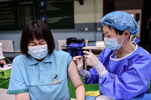 Una estudiante recibe la vacuna Sinopharm contra la COVID-19 en una escuela secundaria en Shenyang, en la provincia de Liaoning, al noreste de China, el 28 de julio de 2021. (STR/AFP a través de Getty Images)