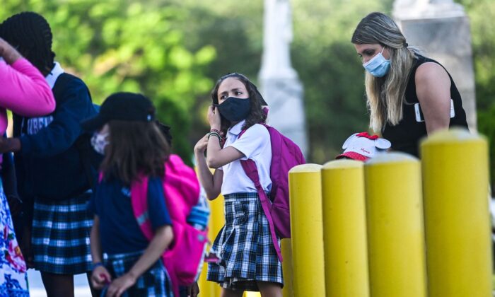 Una estudiante usa una mascarilla cuando ingresa a la Escuela Católica St. Lawrence, el primer día de clases después de las vacaciones de verano, en el norte de Miami, el 18 de agosto de 2021. (Chandan Khanna/AFP a través de Getty Images)