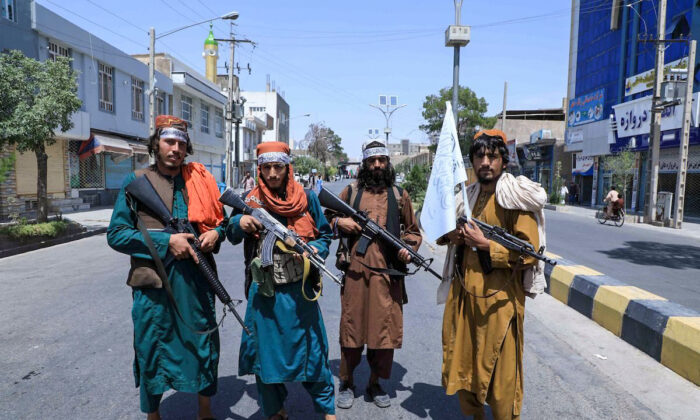 Combatientes talibanes montan guardia a lo largo de una carretera, cerca del sitio de una procesión que conmemoraba la muerte del Imam Hussein, nieto del profeta Mahoma, en Herat, el 19 de agosto de 2021, durante la toma militar de Afganistán por los talibanes. (Aref Karimi/AFP a través de Getty Images)