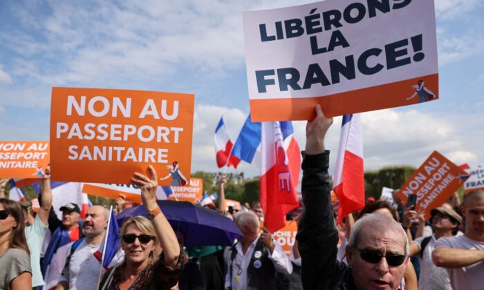 Un grupo de personas sostiene pancartas en las que se lee "no al pase sanitario" (i) y "liberemos a Francia" durante una manifestación en París el 4 de septiembre de 2021. (THOMAS COEX/AFP vía Getty Images)