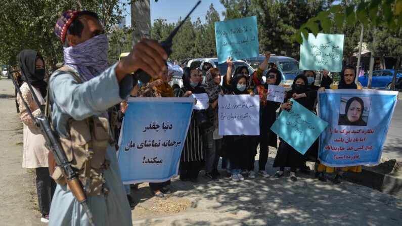 Un talibán (i) hace guardia mientras las mujeres afganas participan en una protesta en Kabul (Afganistán) el 8 de septiembre de 2021. (Hoshang Hashimi/AFP vía Getty Images)