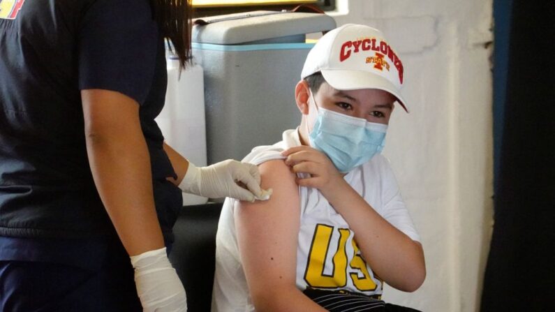 Un niño recibe la primera dosis de la vacuna Pfizer/BioNTech contra la COVID-19 en una escuela privada en Quito el 13 de septiembre de 2021. (RODRIGO BUENDIA/AFP a través de Getty Images)