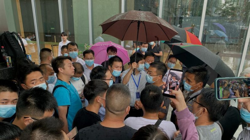 La gente se reúne fuera de la sede de Evergrande en Shenzhen, sureste de China, el 14 de septiembre de 2021. (Noel Celis/AFP vía Getty Images)